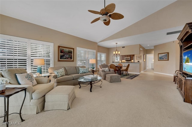 living area with light carpet, ceiling fan with notable chandelier, high vaulted ceiling, and baseboards