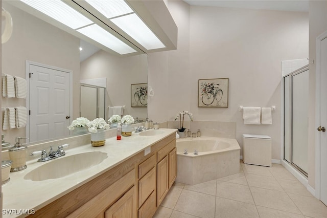 full bath featuring a sink, a shower stall, tile patterned flooring, and a garden tub