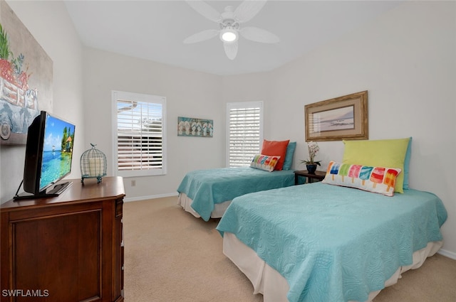 bedroom featuring light carpet, baseboards, and ceiling fan