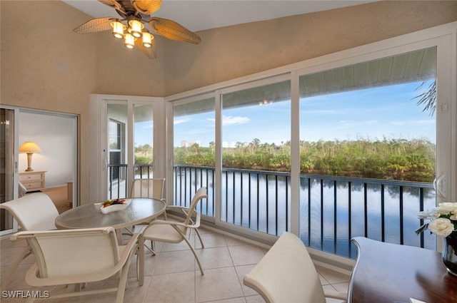 sunroom with a water view and ceiling fan