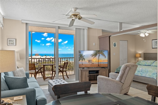 living room with light tile patterned flooring, ceiling fan, and a textured ceiling