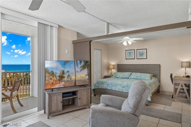 tiled bedroom featuring a textured ceiling, access to exterior, ceiling fan, and a closet