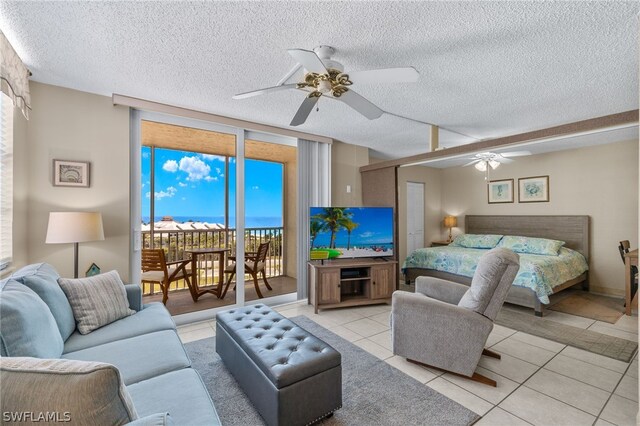 bedroom with ceiling fan, a textured ceiling, access to outside, and light tile patterned floors