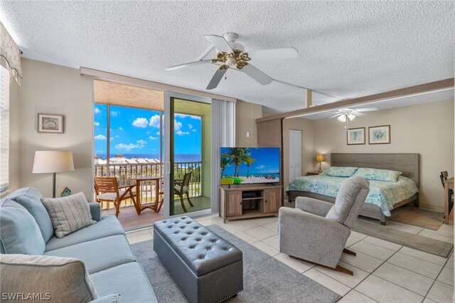 tiled bedroom with access to exterior, a textured ceiling, and ceiling fan