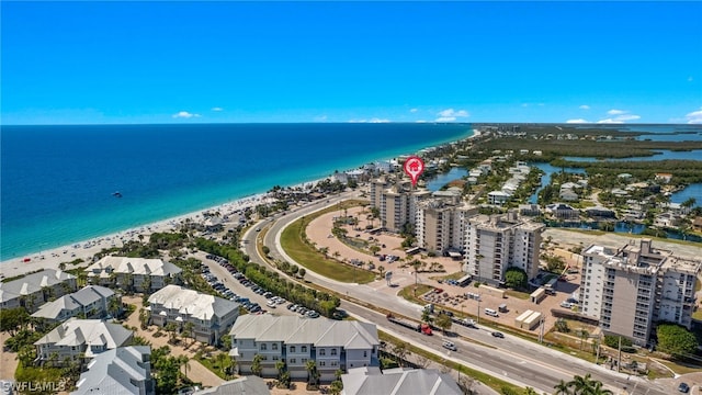 birds eye view of property with a water view and a beach view