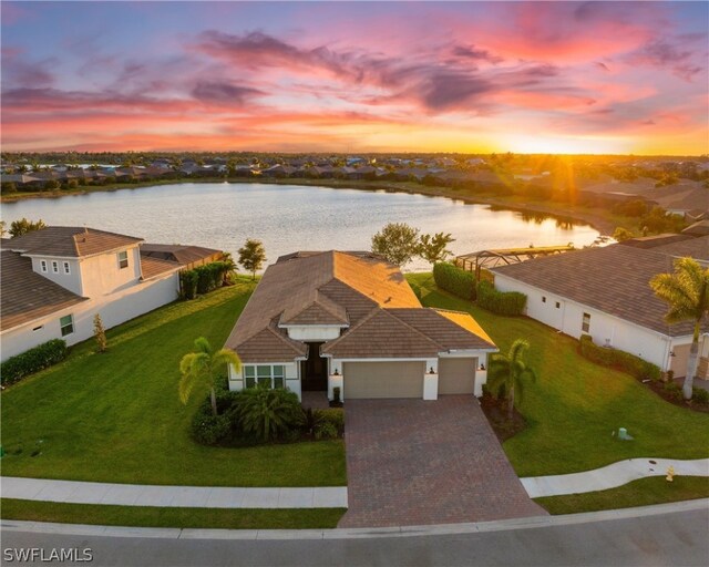 aerial view at dusk featuring a water view