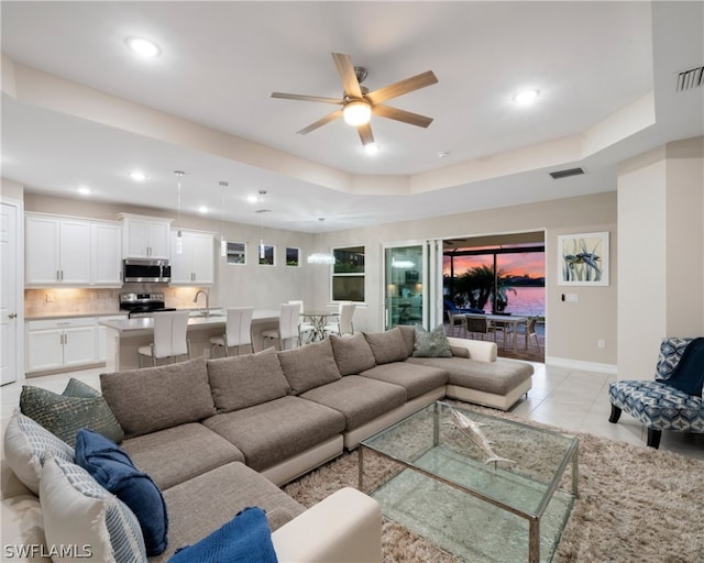 living room featuring recessed lighting, a raised ceiling, visible vents, and light tile patterned flooring