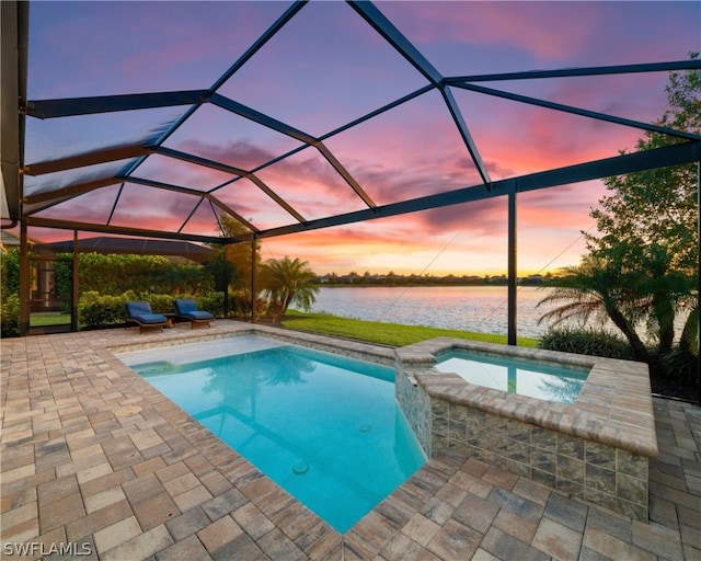 view of pool with a pool with connected hot tub, glass enclosure, a water view, and a patio