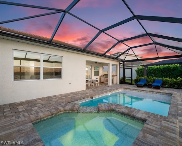 view of pool with ceiling fan, glass enclosure, a patio, and a pool with connected hot tub