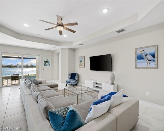 living room featuring ceiling fan, a tray ceiling, baseboards, and recessed lighting