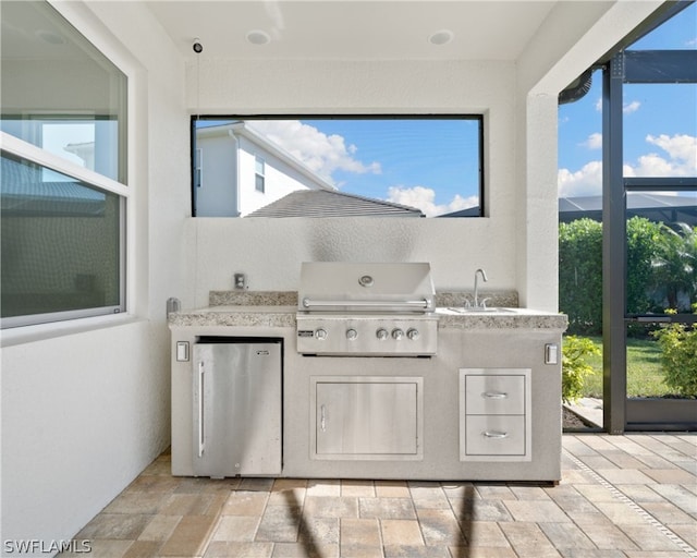 view of patio with a grill, an outdoor kitchen, and a sink