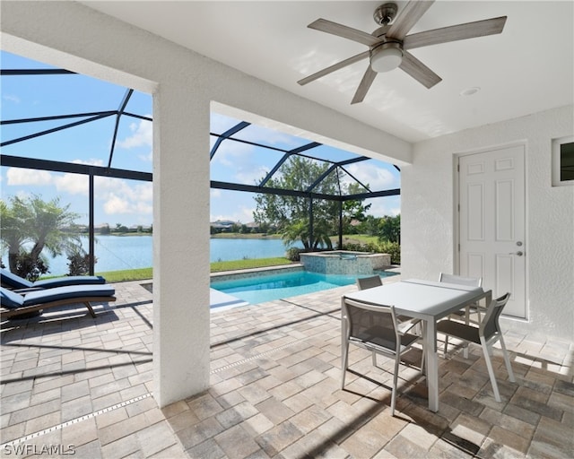 view of pool featuring glass enclosure, a patio area, a water view, and a pool with connected hot tub