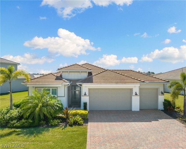 view of front of home featuring a garage, a tile roof, a front lawn, and decorative driveway