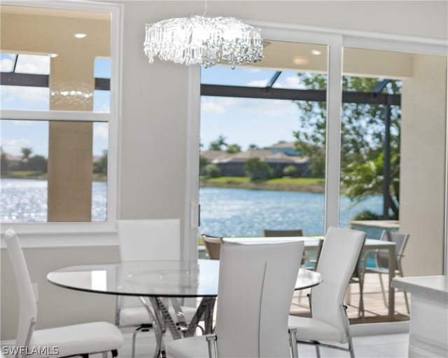 dining room featuring a water view and a chandelier