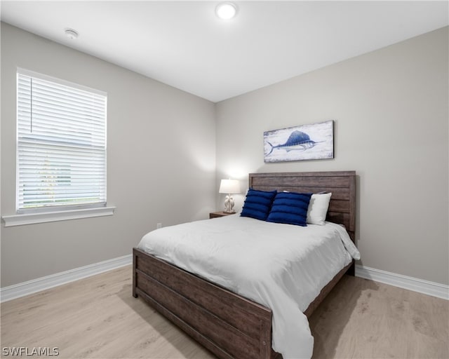 bedroom with light wood-type flooring and baseboards