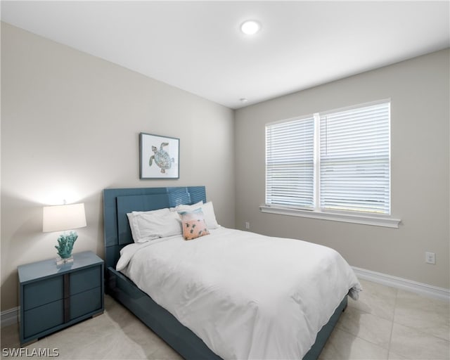 bedroom with light tile patterned flooring and baseboards