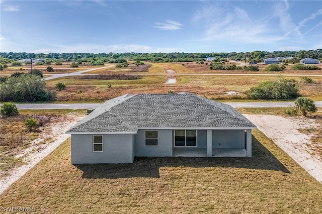 view of home's exterior with a yard, a rural view, and a patio