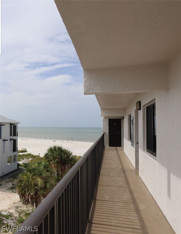 balcony featuring a water view and a view of the beach