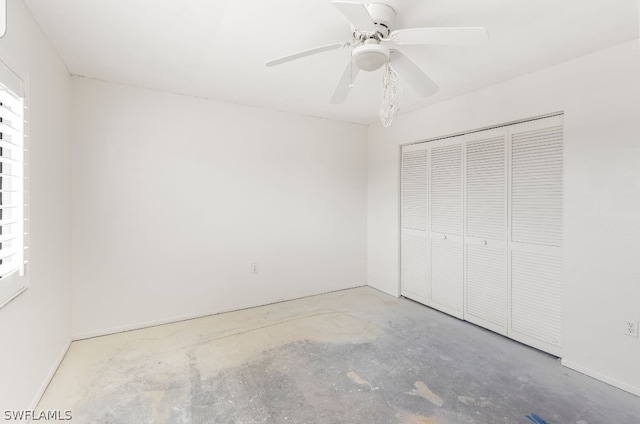 unfurnished bedroom with ceiling fan, concrete flooring, and a closet