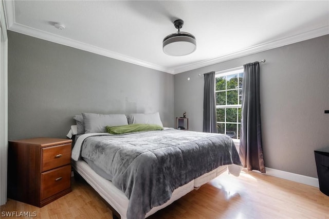 bedroom featuring light hardwood / wood-style flooring and crown molding