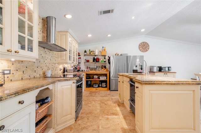 kitchen with light stone countertops, wall chimney exhaust hood, backsplash, vaulted ceiling, and a kitchen island with sink