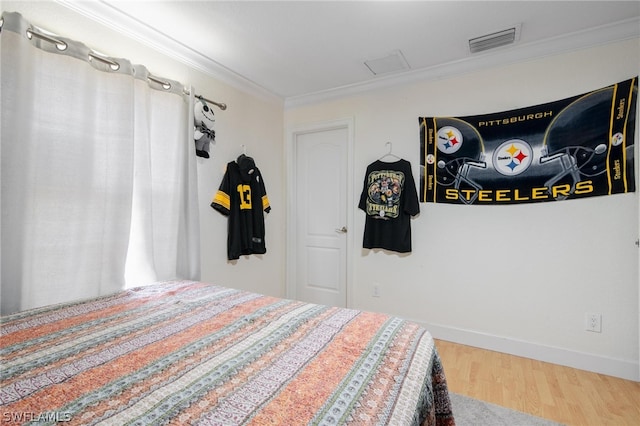 bedroom with hardwood / wood-style floors and ornamental molding