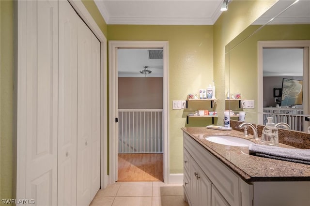 bathroom featuring tile patterned floors, crown molding, and vanity