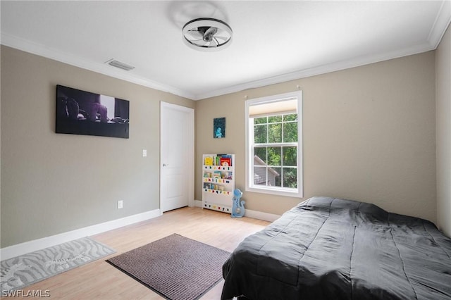 bedroom with light hardwood / wood-style flooring and crown molding