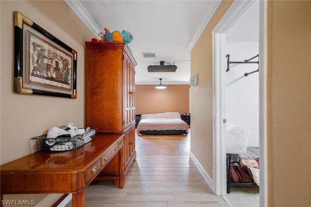 hall with ornamental molding and light hardwood / wood-style flooring