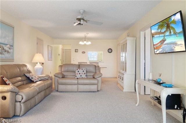 carpeted living room with ceiling fan with notable chandelier