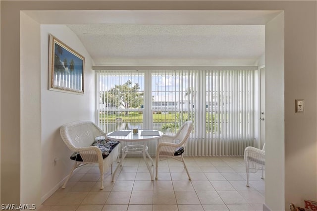 unfurnished room featuring light tile floors, a textured ceiling, and lofted ceiling