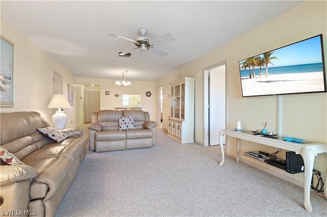 carpeted living room featuring ceiling fan with notable chandelier