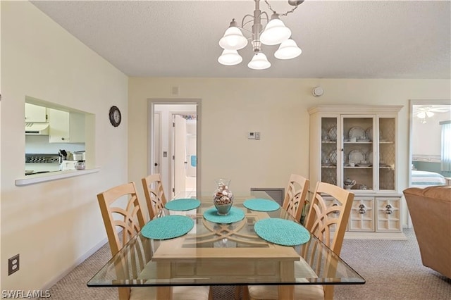 carpeted dining room featuring a chandelier and a textured ceiling