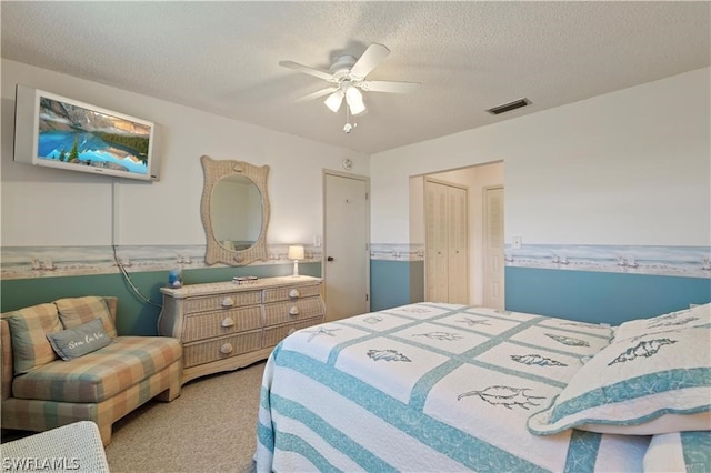 carpeted bedroom featuring a closet, ceiling fan, and a textured ceiling