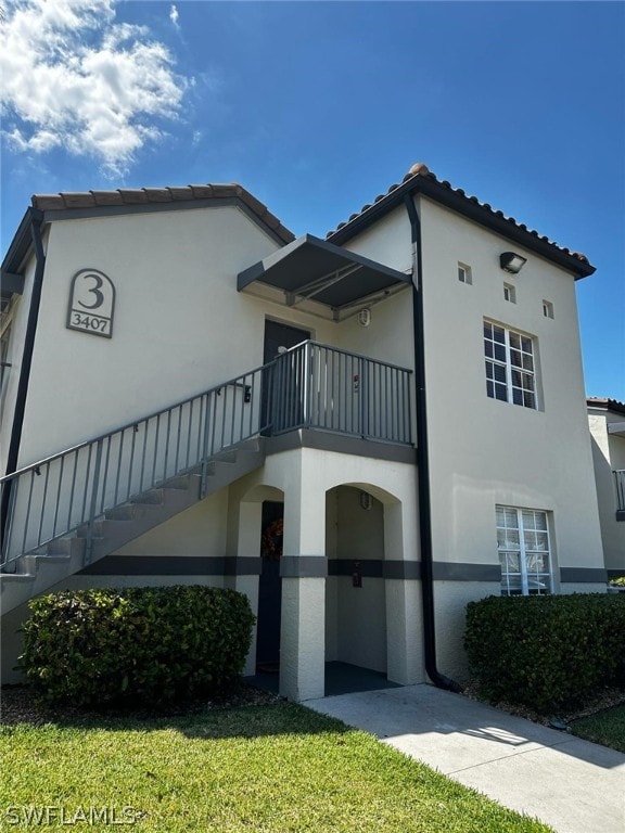 view of front facade with a balcony and a front lawn