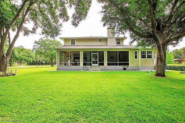 back of house with a yard and a sunroom