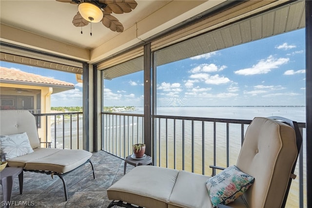 sunroom / solarium with a water view and ceiling fan