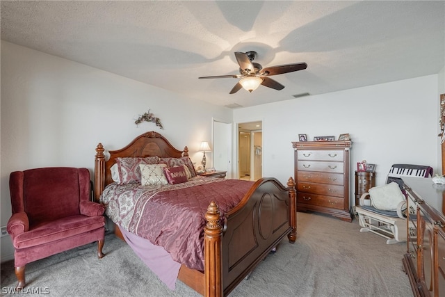 bedroom with a textured ceiling, carpet floors, and ceiling fan