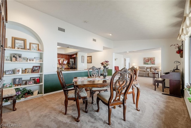 dining area with built in shelves and carpet