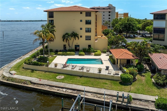 view of swimming pool featuring a water view and a lawn