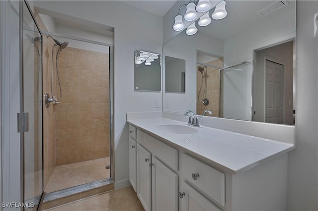 bathroom featuring vanity, a shower with door, and tile patterned flooring