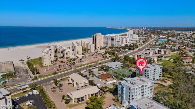 birds eye view of property with a water view and a beach view