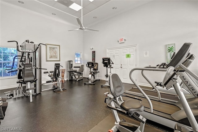 exercise room featuring plenty of natural light, ceiling fan, and a towering ceiling