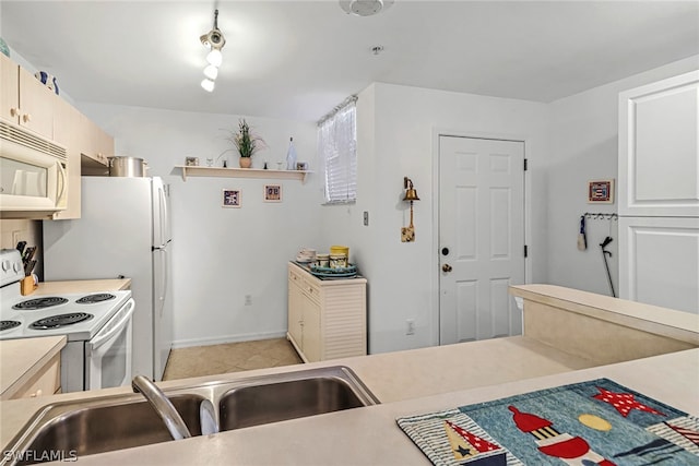 kitchen with sink, white appliances, and light tile floors