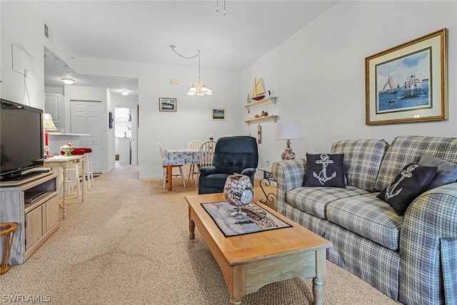 living room with a notable chandelier and light carpet