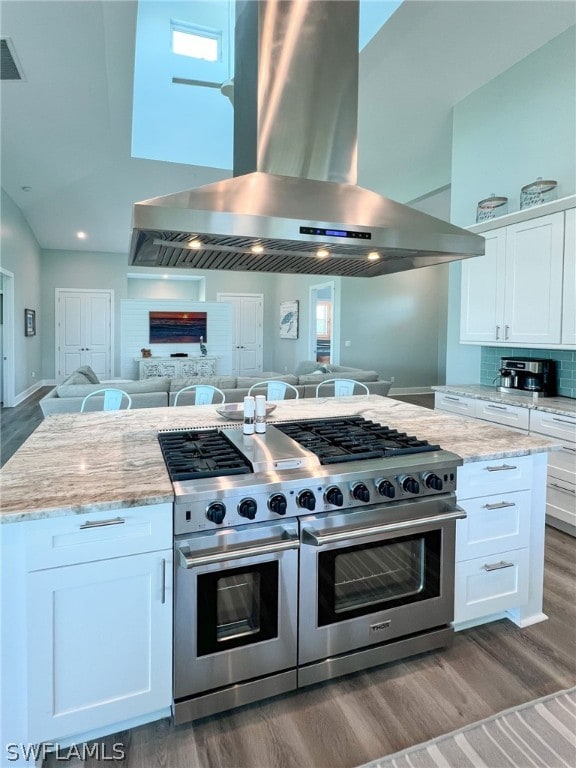 kitchen featuring white cabinets, light hardwood / wood-style flooring, light stone countertops, and extractor fan