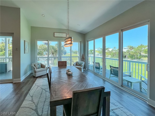 dining space with vaulted ceiling and dark wood-type flooring