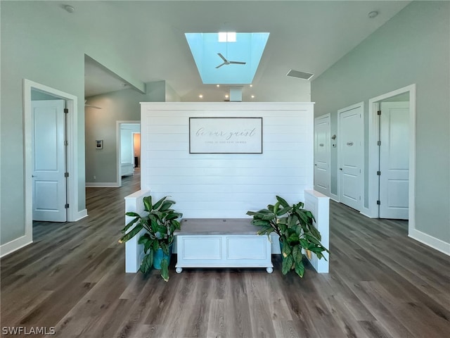 interior space with dark hardwood / wood-style flooring and vaulted ceiling with skylight