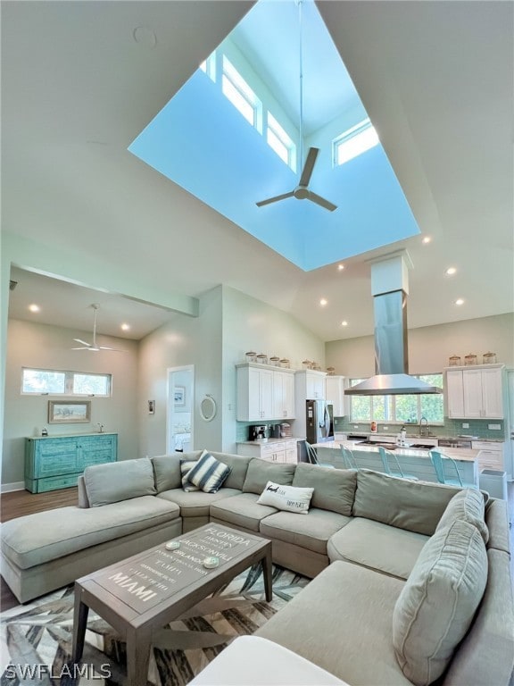 living room featuring high vaulted ceiling, ceiling fan, and light hardwood / wood-style floors