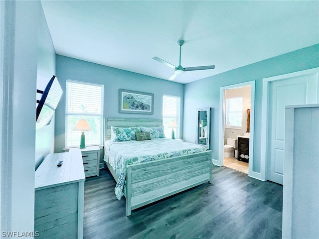 bedroom with ensuite bath, dark hardwood / wood-style flooring, ceiling fan, and multiple windows